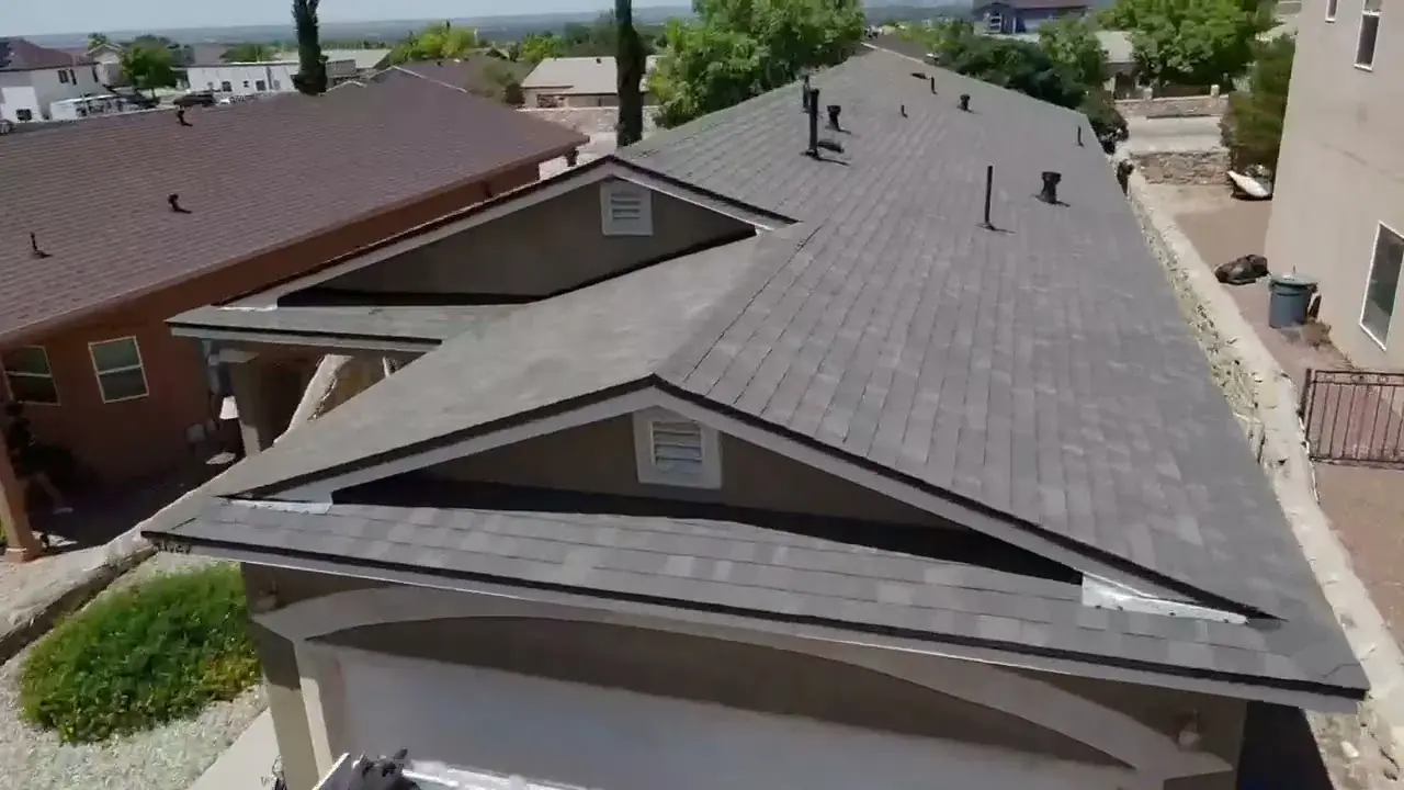 Aerial view of a finished architectural shingle roof on a Las Cruces home, with vents and ridge lines visible