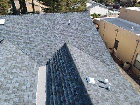 Close aerial view of an asphalt shingle roof ridge and valley