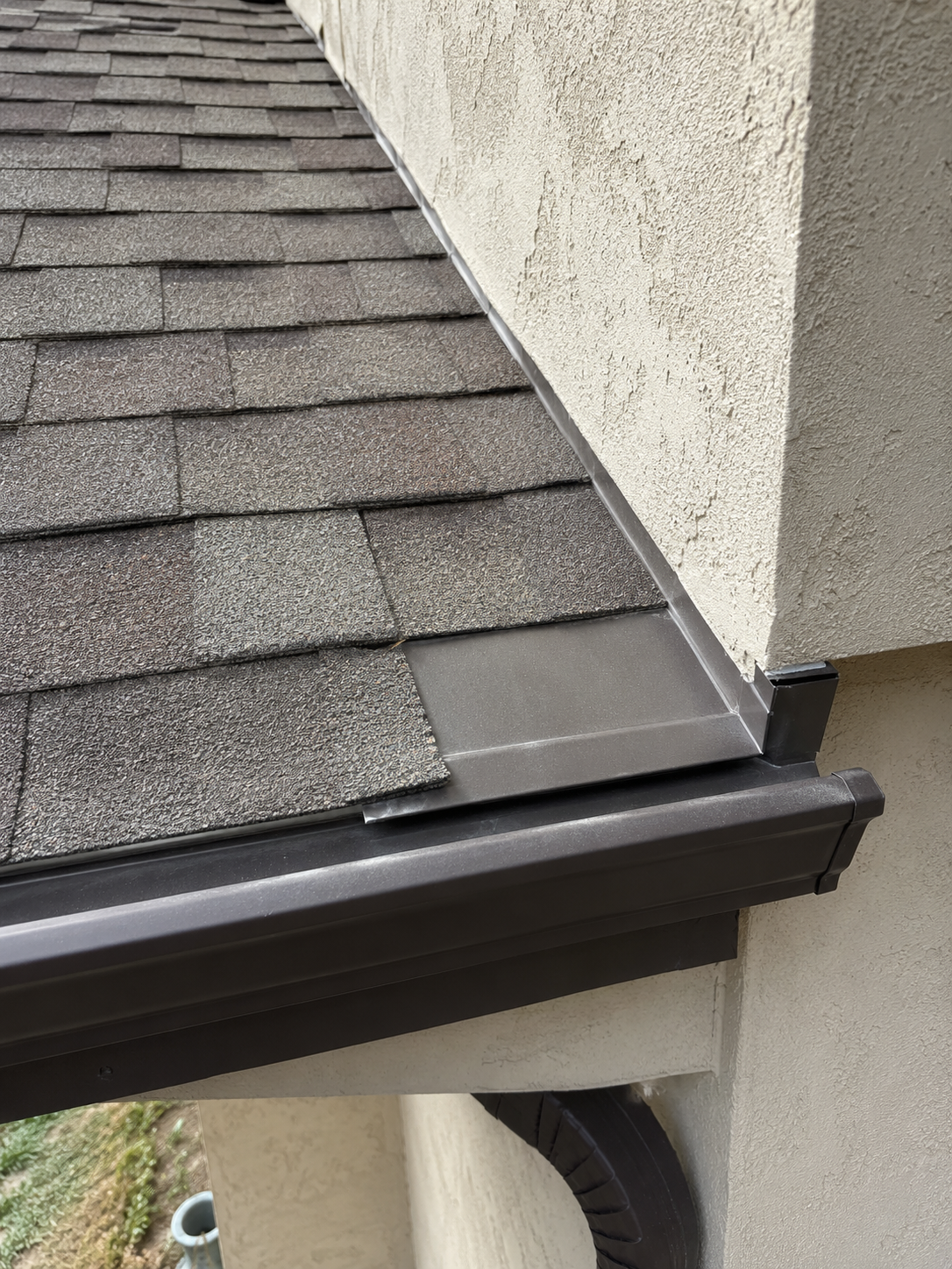 Roofer inspecting gutters and roofline from a ladder