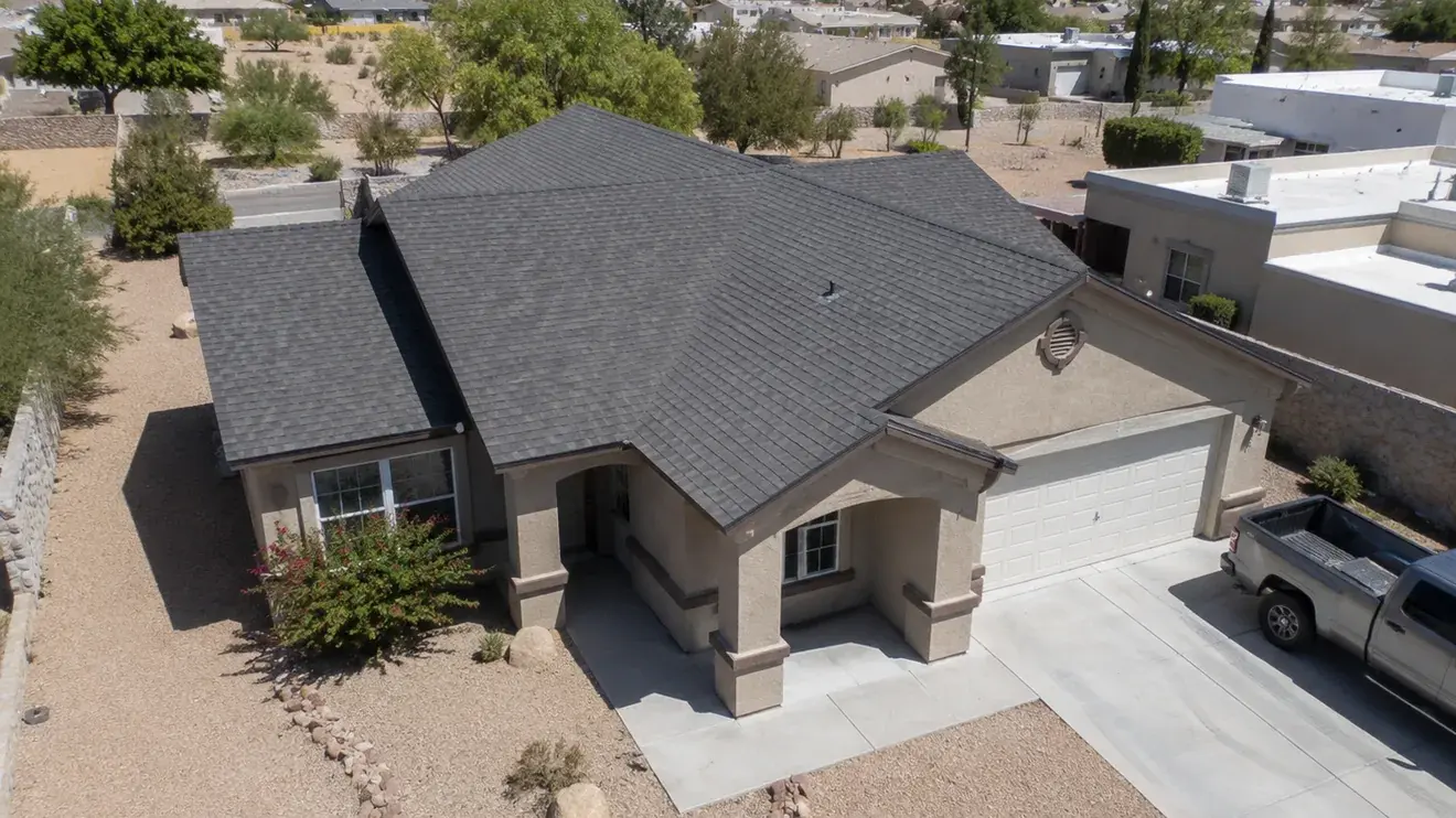 Aerial view of a well-kept shingle roof on a stucco home in a Las Cruces desert neighbourhood