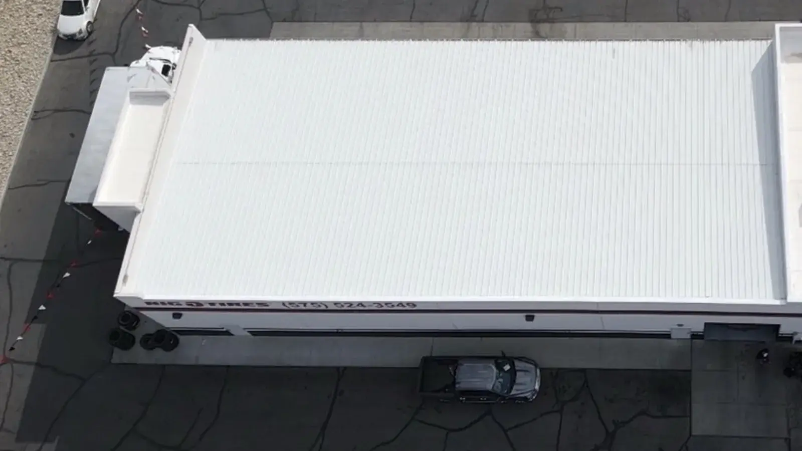 Overhead view of a white standing seam metal roof with raised vertical seams on a commercial building in Las Cruces