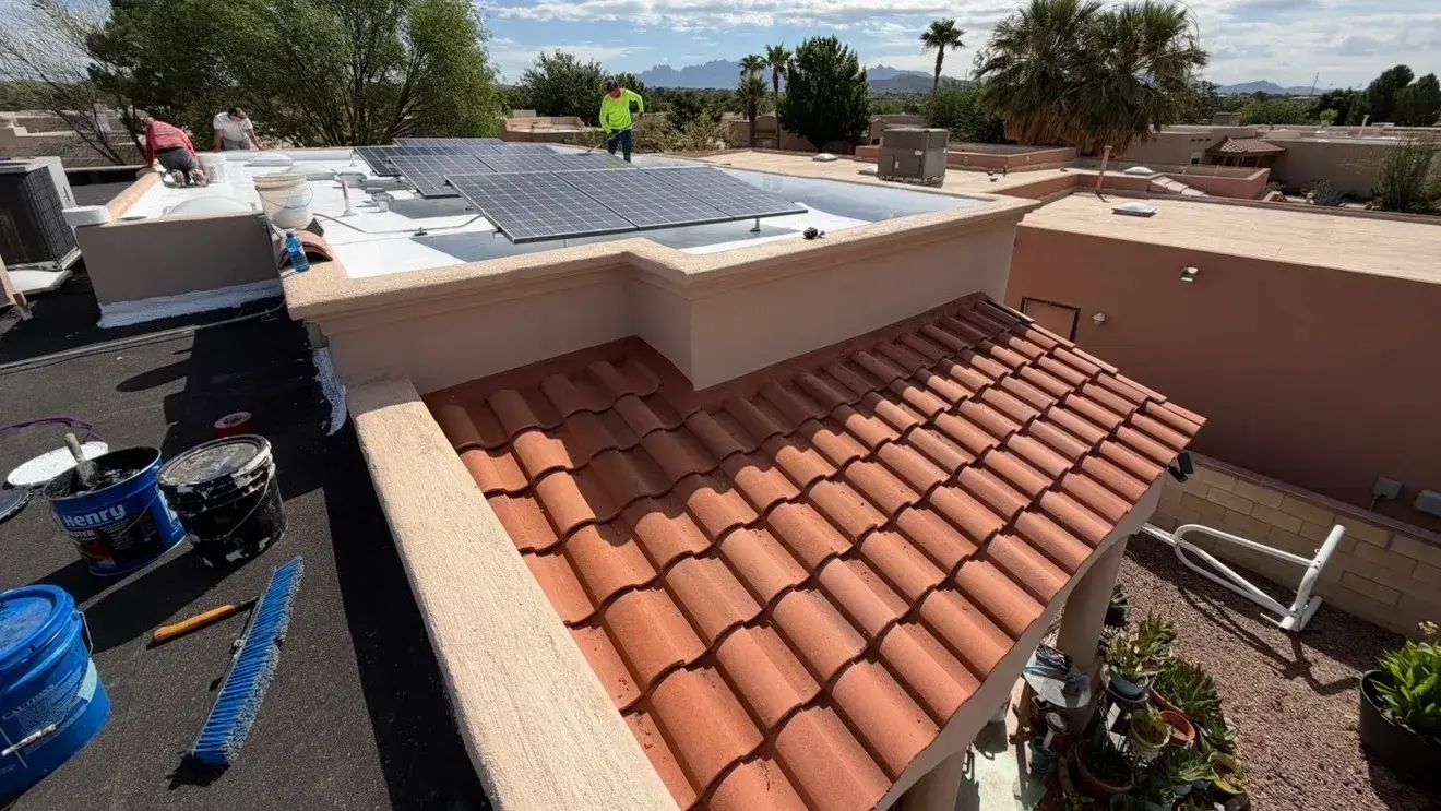 Stucco parapet wall and cap between a flat roof under repair and a clay tile roof section on a Las Cruces home